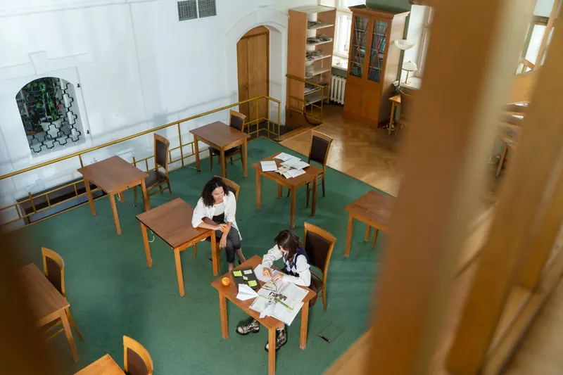 Studierende arbeiten gemeinsam an Lernunterlagen in einer Hochschulbibliothek